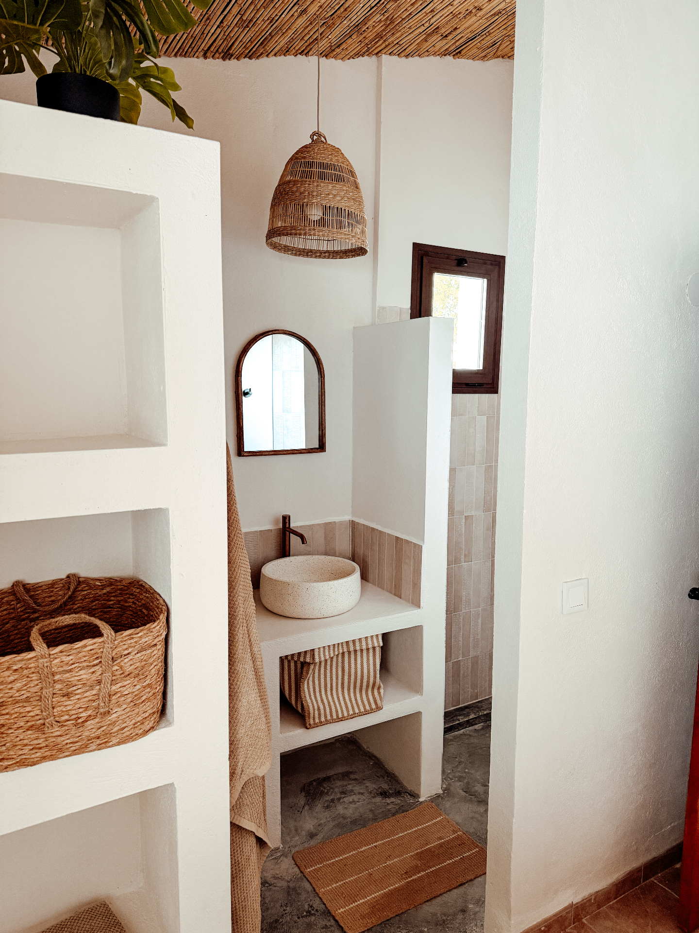 Ensuite bathroom with concrete sink and rattan pendant
