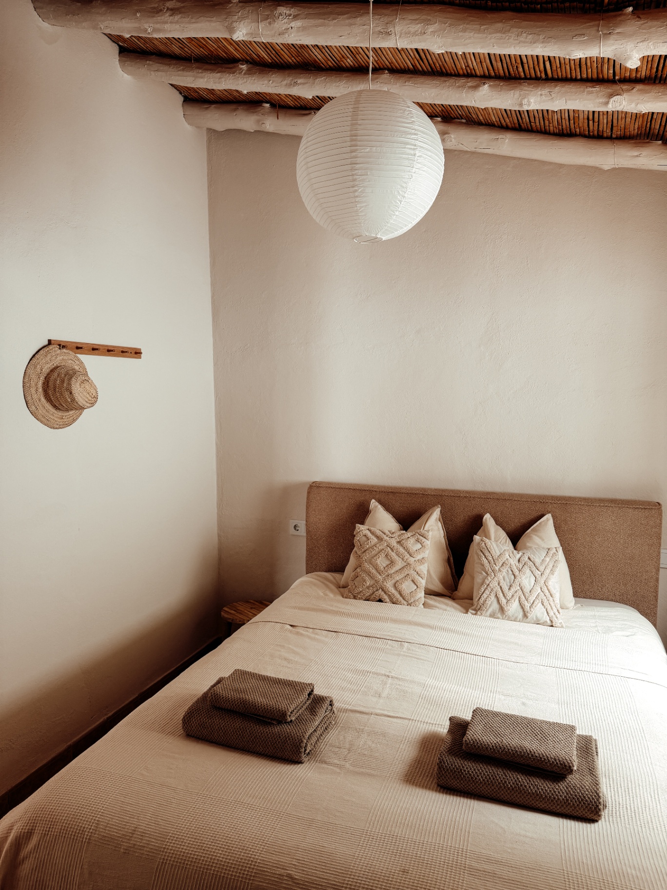Cozy bedroom with bamboo ceiling and natural linen bedding